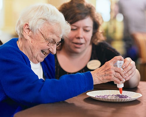 caregiver helping resident with a craft
